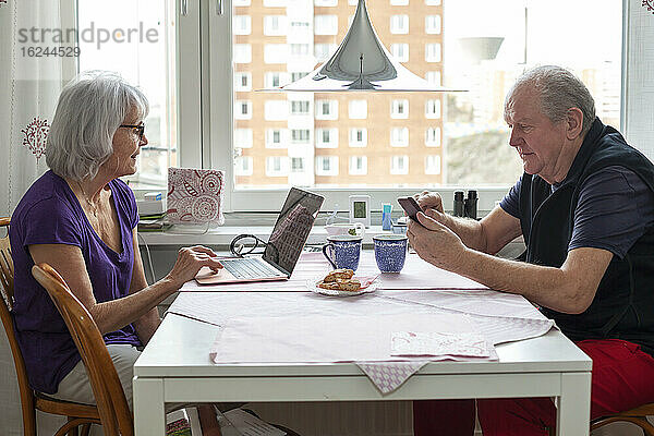 Älteres Paar sitzt am Tisch