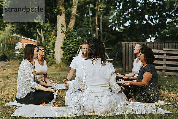 Menschen meditieren im Garten