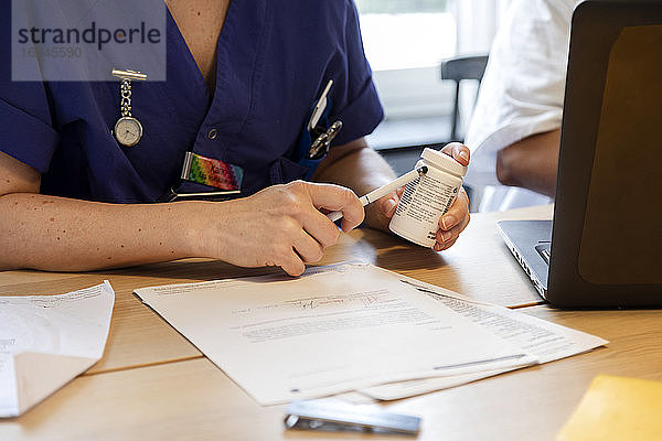 Krankenschwester hält Pillenflasche in der Hand