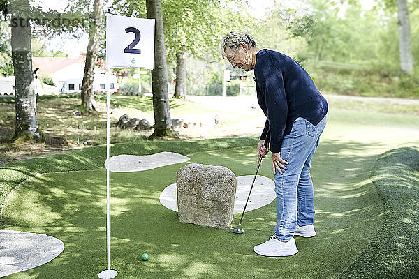 Frau spielt Minigolf