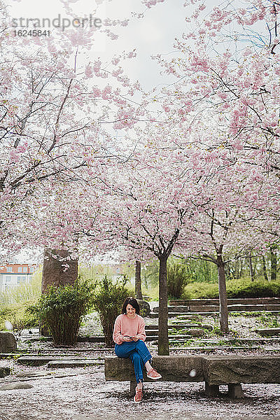 Frau sitzt auf einer Parkbank