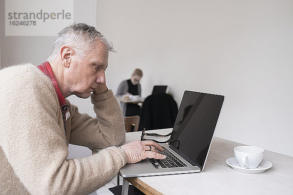 Älterer Mann mit Laptop