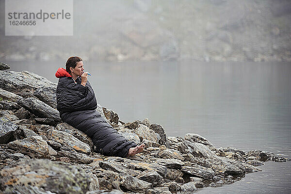 Frau im Schlafsack am See