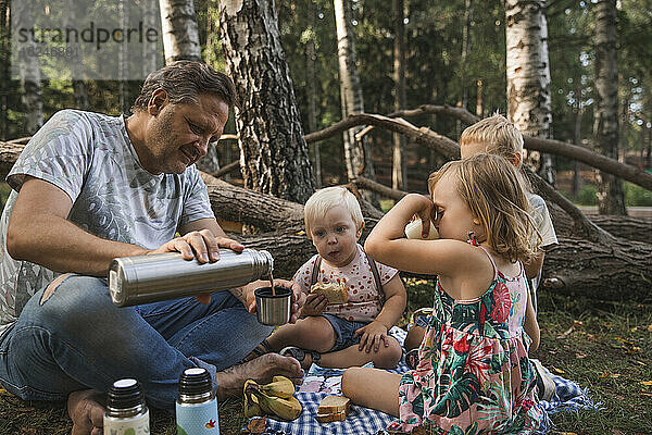 Vater mit Kindern beim Picknick