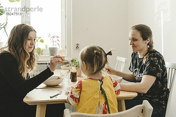 Familie mit Tochter am Tisch sitzend