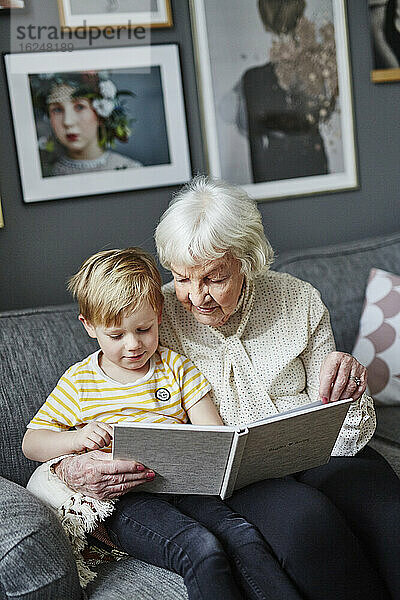Großmutter liest ihrem Enkel ein Buch vor