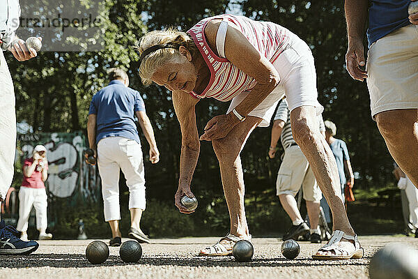 Frau spielt Pv©tanque