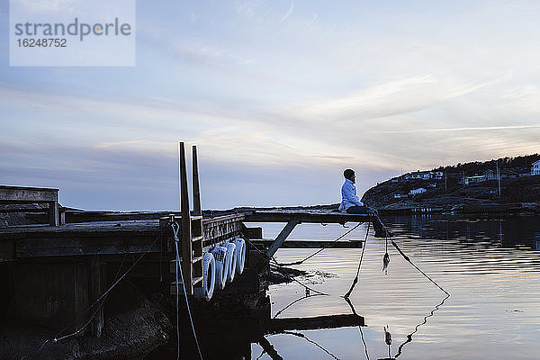 Person auf Steg im Meer