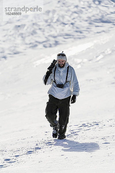 Mann im Winter mit Gewehr