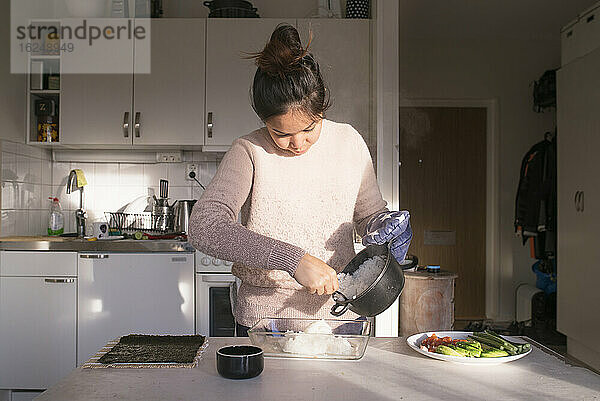 Frau bereitet Essen in der Küche zu