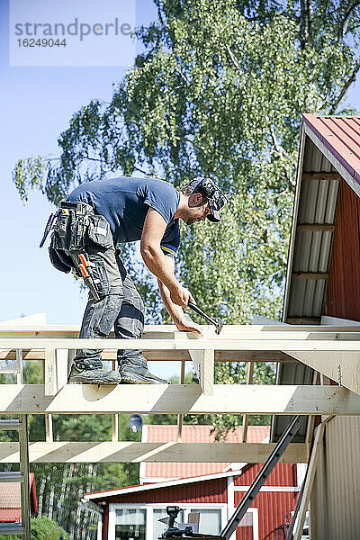 Zimmermann arbeitet auf dem Dach