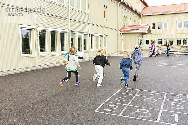 Kinder laufen auf dem Schulhof