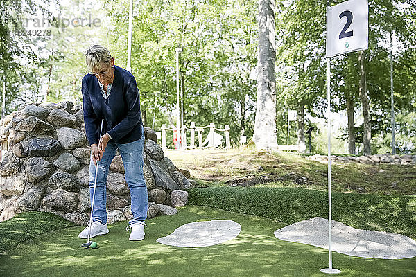 Frau spielt Minigolf