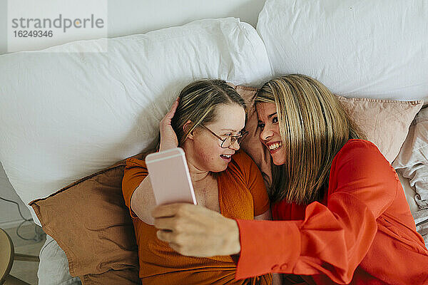 Schwestern auf dem Bett machen Selfie