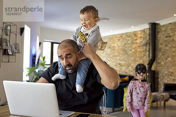 Mann mit Kindern am Laptop