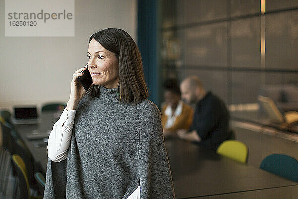 Geschäftsfrau benutzt Telefon im Sitzungssaal
