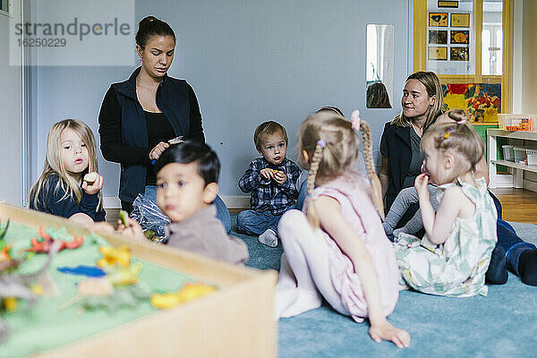 Erzieherinnen mit Kindern im Kindergarten