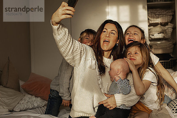 Mutter mit Kindern nimmt Selfie