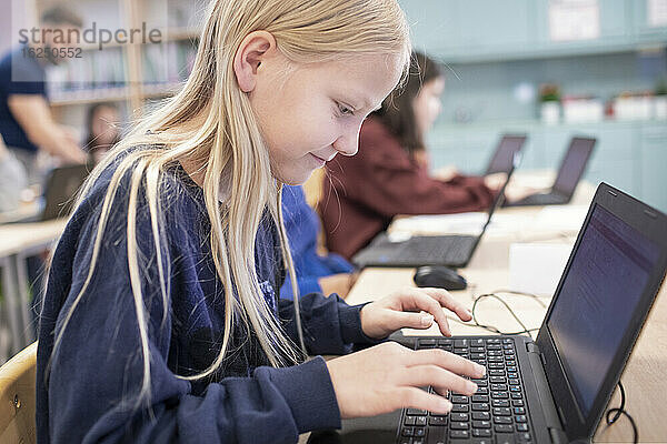 Mädchen im Klassenzimmer mit Laptop