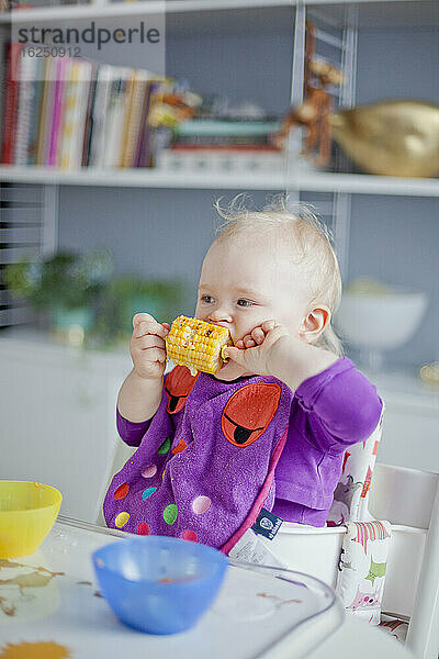 Kleines Mädchen isst Maiskolben