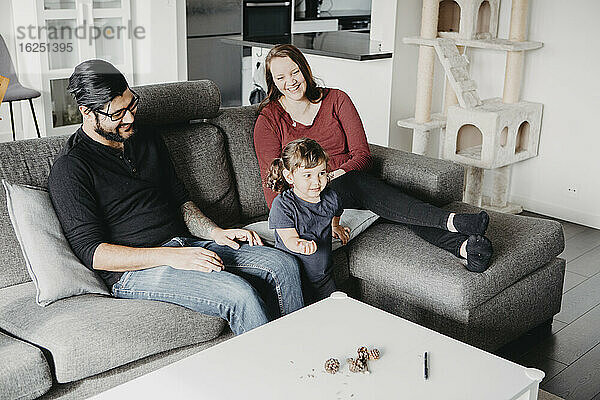 Eltern mit Tochter auf Sofa
