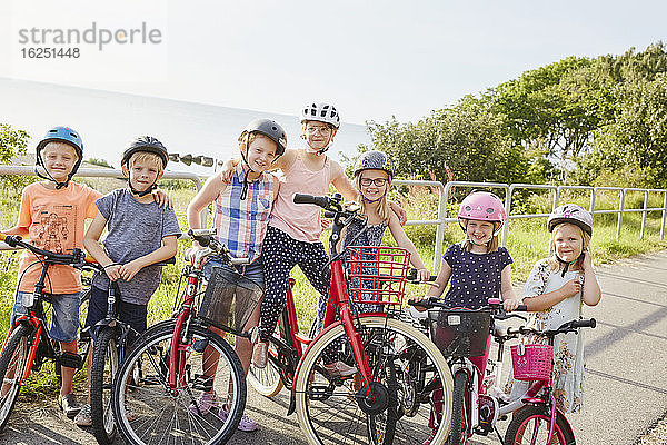 Kinder mit Fahrrädern stehend