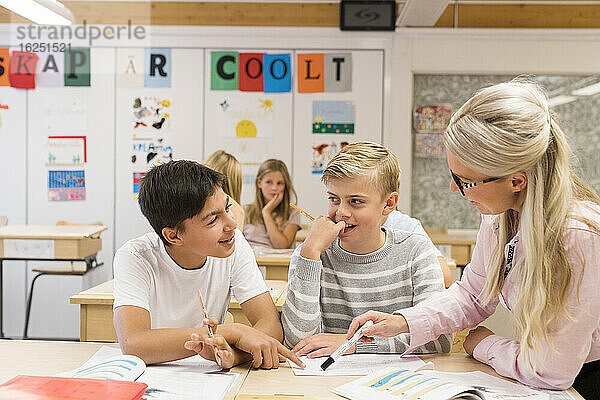 Lehrerin hilft Jungen im Klassenzimmer