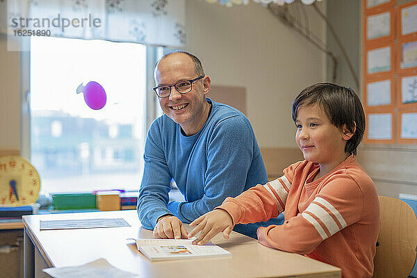 Lehrer hilft Jungen im Klassenzimmer