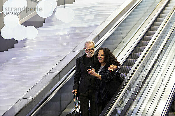 Älteres Paar auf Rolltreppe