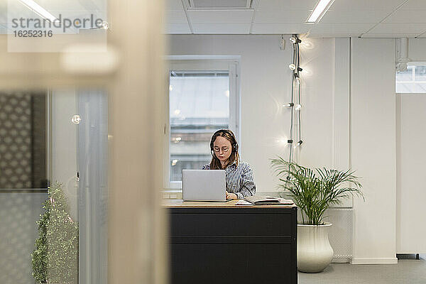 Frau mit Headset bei der Arbeit im Büro