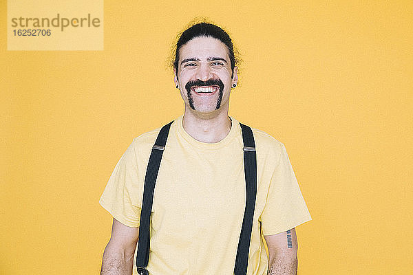 Porträt eines glücklichen reifen Mannes vor gelbem Hintergrund