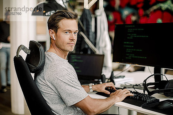 Porträt eines männlichen Computerprogrammierers  der im Büro arbeitet