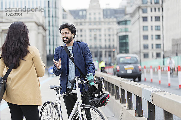 Geschäftsleute mit Fahrrad sprechen auf Stadtbrücke