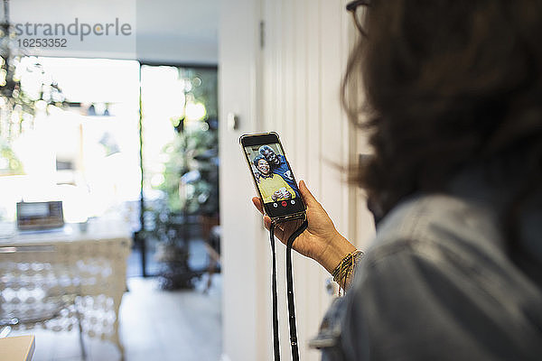 Frau im Video-Chat mit Freunden auf dem Bildschirm eines Smartphones