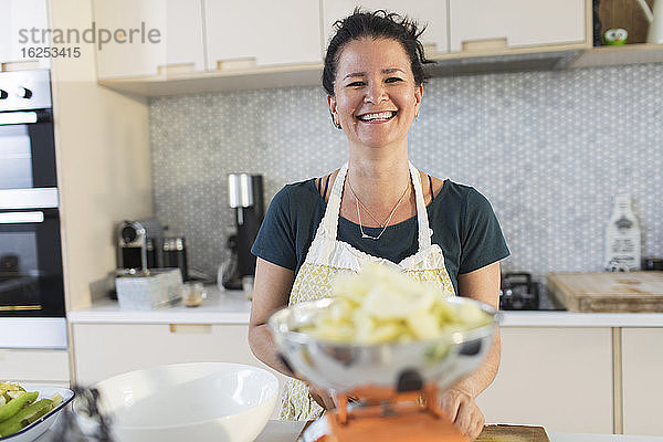 Porträt einer glücklichen Frau beim Kochen in der Küche