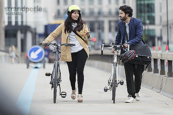 Geschäftsleute im Gespräch und zu Fuß mit dem Fahrrad auf der Stadtbrücke