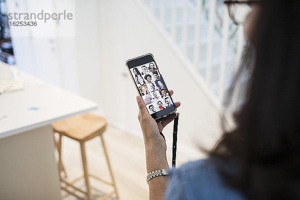 Frau im Video-Chat mit Kollegen auf dem Bildschirm eines Smartphones