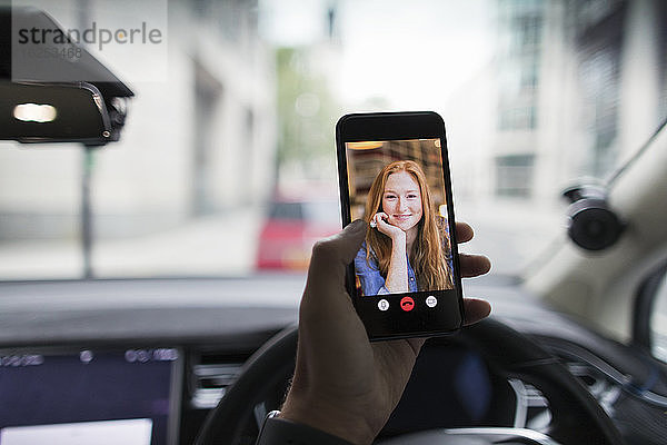 POV Video-Chat der Frau auf dem Bildschirm eines Smartphones im Auto