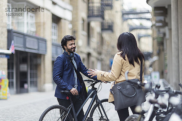 Geschäftsleute mit Fahrrädern im Gespräch auf der Straße