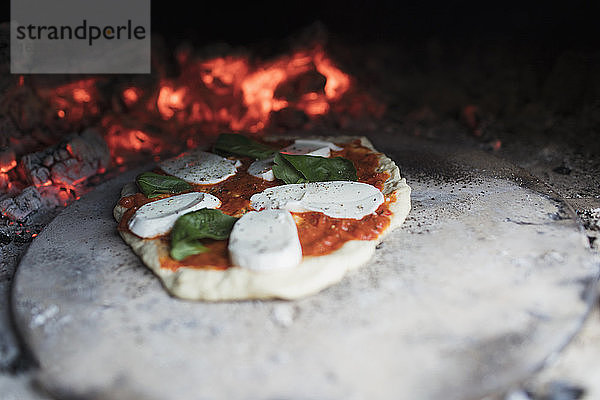 Hausgemachte Margherita-Pizza auf Stein im heißen Pizzaofen