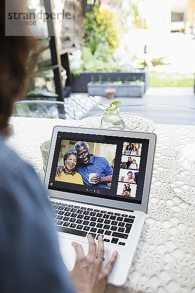 Frau im Video-Chat mit Familie und Freunden am Laptop-Bildschirm