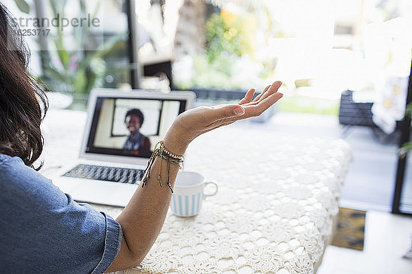 Videokonferenz einer Frau mit einer Kollegin am Laptop-Bildschirm zu Hause