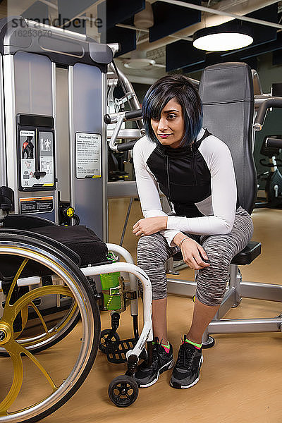 Eine querschnittsgelähmte Frau  die sich nach dem Training in einer Fitnesseinrichtung mit einer Überkopfpresse ausruht und nachdenklich ist; Sherwood Park  Alberta  Kanada