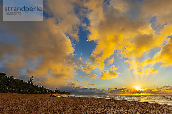 Silhouette von Surfern am Kelki Beach mit dramatisch leuchtenden Wolken darüber bei Sonnenuntergang; Oahu  Hawaii  Vereinigte Staaten von Amerika