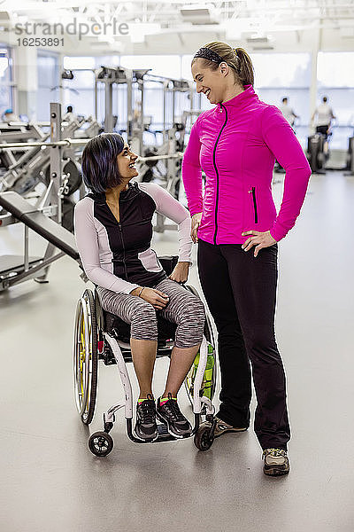 Eine querschnittsgelähmte Frau im Gespräch mit ihrem Personal Trainer und ihrem Trainer nach einem erfolgreichen Training in einer Freizeiteinrichtung: Sherwood Park  Alberta  Kanada