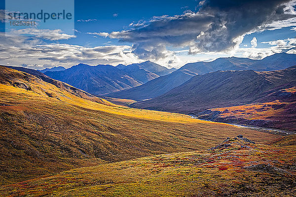 Die Brooks Mountains und das Kuyuktuvuk Creek Valley in Herbstfarben unter blauem Himmel. Tore des Arktischen Nationalparks und Naturschutzgebietes  Arktisches Alaska im Herbst; Alaska  Vereinigte Staaten von Amerika