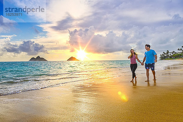 Ein Paar spaziert bei Sonnenuntergang am Strand von Lanakai auf der hawaiianischen Insel Oahu; Lanakai  Oahu  Hawaii  Vereinigte Staaten von Amerika