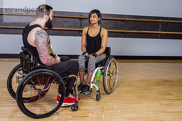 Zwei querschnittsgelähmte Freunde  die nach dem Training in einer Fitnesseinrichtung miteinander reden und sich gegenseitig ermutigen: Sherwood Park  Alberta  Kanada