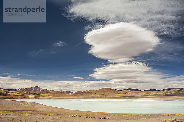 Südamerikanische Hochgebirgslagune (kleiner See) mit linsenförmigen Wolken darüber; San Pedro de Atacama  Atacama  Chile