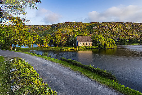 Eine kleine Straße  die den See hinunter nach Gougane Barra führt  mit Hügeln im Hintergrund im Spätsommer; Gougane Barra  Grafschaft Cork  Irland